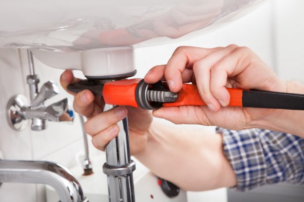 depositphotos_29295307-stock-photo-young-plumber-fixing-a-sink